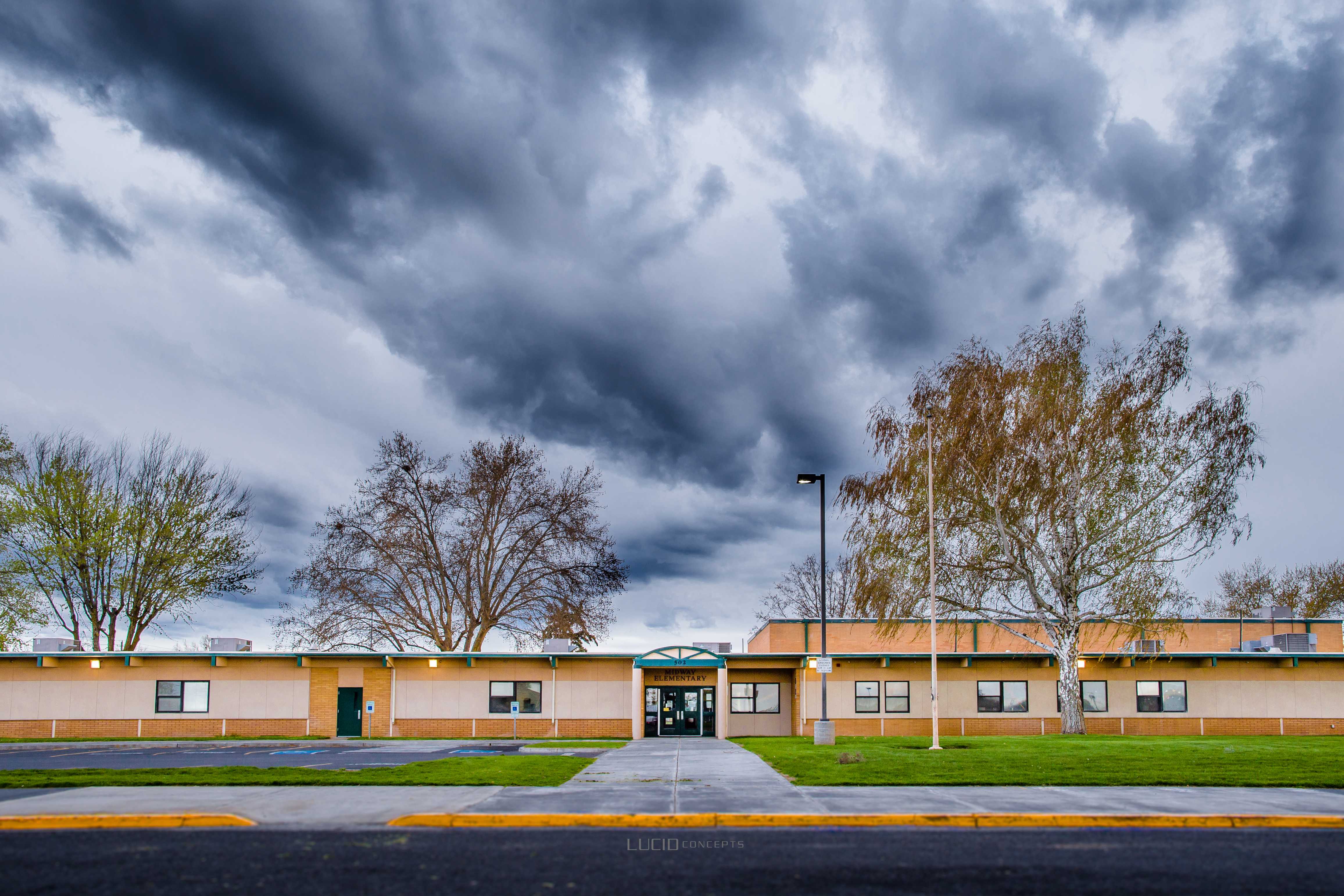 old school with a tree out front, dark sky